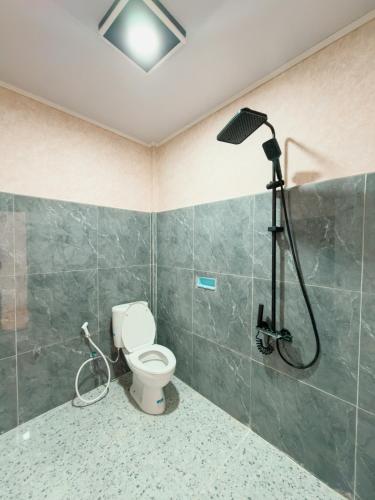 a bathroom with a shower and a toilet at Rodeo Inn in Ambarita