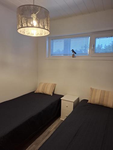 a bedroom with two beds and a chandelier at Starvillas B201 in Kalajoki