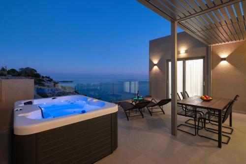 een jacuzzi op het dak van een huis bij Aquamarine Luxury Suites - Stegna in Archangelos