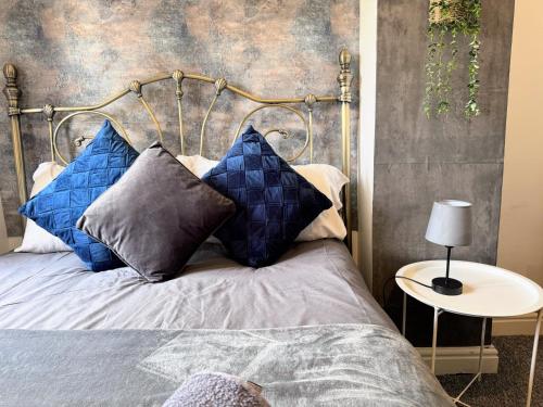 une chambre avec un lit avec des oreillers bleus dans l'établissement Canterbury Luxe Stay, à Hackington