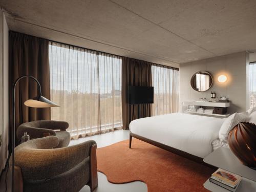 a hotel room with a large bed and a chair at Hotel V Oosterpark in Amsterdam