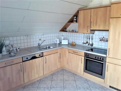 een keuken met houten kasten en een spoelbak bij Ferienwohnung Frischkorn in Steinau an der Straße