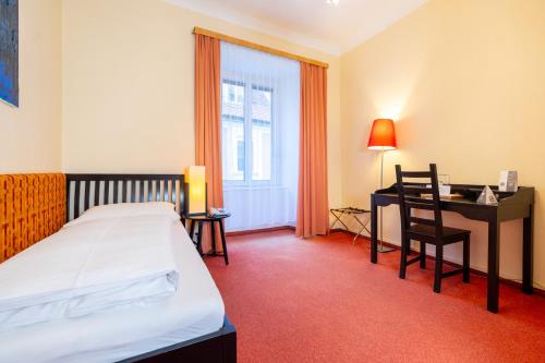 a hotel room with a bed and a desk at Hotel Mariahilf im Stadtzentrum in Graz