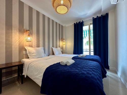 een slaapkamer met een groot bed met een blauwe deken bij Palais du SOLEIL MONACO Terrasse & Parking in Beausoleil