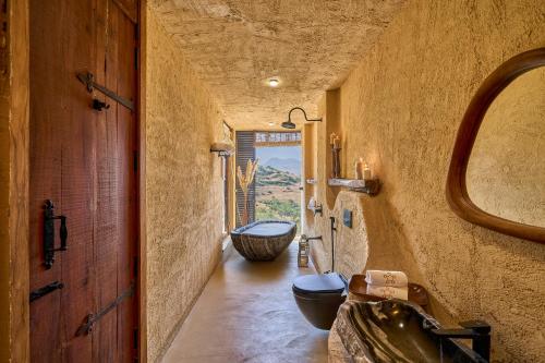 a bathroom with a sink and a toilet and a tub at SaffronStays Villa Reya in Trimbak