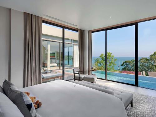 ein Schlafzimmer mit einem großen weißen Bett und einem Pool in der Unterkunft V Villas Phuket - MGallery Collection in Panwa Beach
