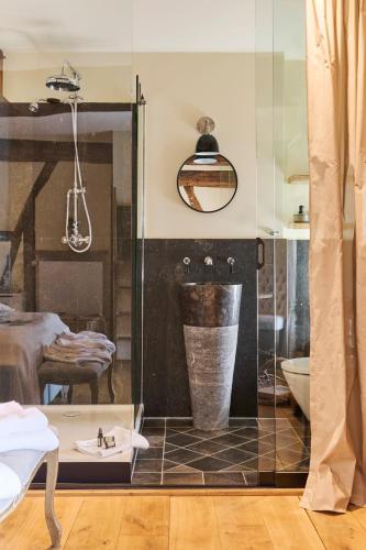 a bathroom with a glass shower with a sink and a toilet at La belle Maison in Sippenaeken