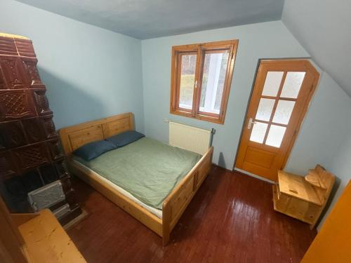- une petite chambre avec un lit et une porte dans l'établissement Cabana Valea Lungă, à Telcişor