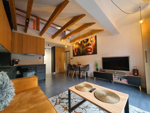ヴィスワにあるApartamenty Ski & Fun Spokojnaのテーブルとテレビのあるリビングルーム