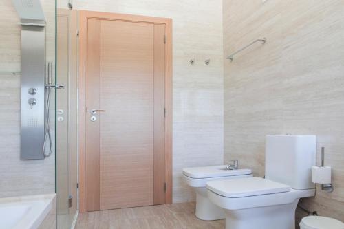 a bathroom with a toilet and a shower and a sink at Monte Girassol - The Lisbon Country House in Quinta das Faias