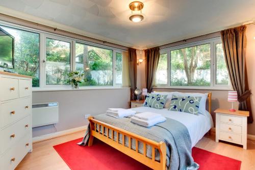 een slaapkamer met een groot bed en een rood tapijt bij 4 Bed in Croyde oc-windy1 in Croyde