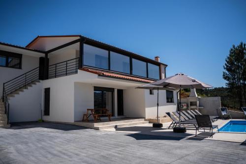 a house with a patio and a swimming pool at Recanto da Boucinha - T3 in Veade