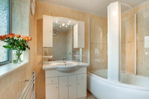 een badkamer met een wastafel en een bad en een wastafel bij 4 Bed in Croyde oc-windy1 in Croyde