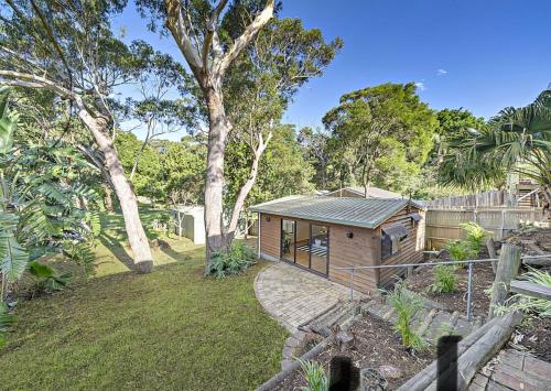 een kleine hut in een tuin met een boom bij Saltbush Retreat in Nelson Bay