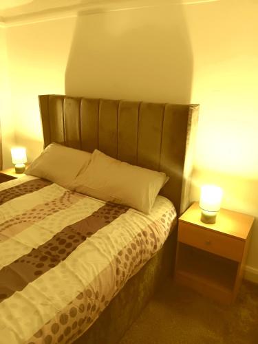 Un dormitorio con una cama y dos lámparas sobre mesas. en High class accommodations 10, en Little Hulton