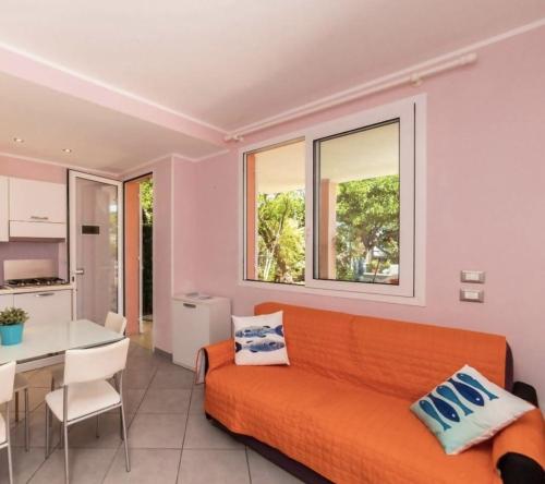 een woonkamer met een oranje bank en een tafel bij La casetta rosa in Diano Marina