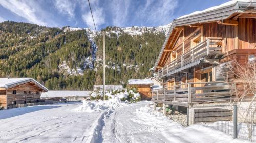 Chalet Follette في شامونيه مون بلان: كوخ خشبي في الثلج بجوار جبل