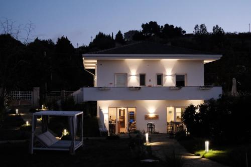 a white house with lights in front of it at L'Amarena Garden House in Matera