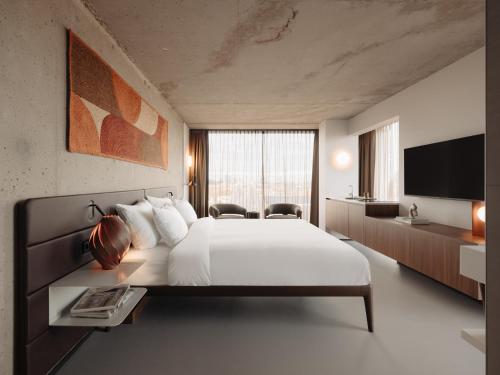 a bedroom with a large bed and a television at Hotel V Oosterpark in Amsterdam