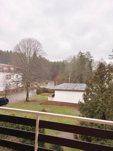 un edificio bianco con una recinzione di fronte di Ferienwohnung Schöntal 1 a Ludwigswinkel