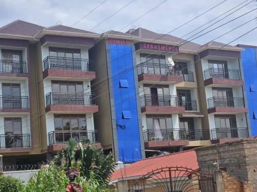 a large building with blue paint on the side of it at Spea Homely Apartments in Mbarara