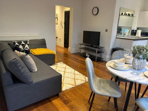 a living room with a couch and a table at Tavistock House-Parking-Sleeps 7-Central in Bedford
