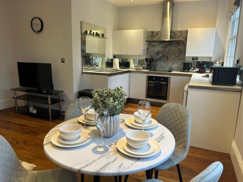 a dining room table with chairs and a kitchen at Tavistock House-Parking-Sleeps 7-Central in Bedford