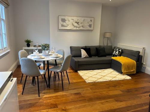 a living room with a couch and a table and chairs at Tavistock House-Parking-Sleeps 7-Central in Bedford