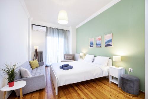una camera da letto con un letto bianco e un divano di Houseloft Bianca Vision a Salonicco