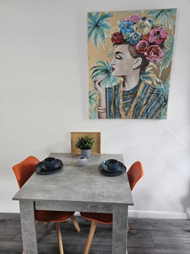 einen Tisch mit Stühlen und ein Bild einer Frau in der Unterkunft Blue light studio in Cardiff
