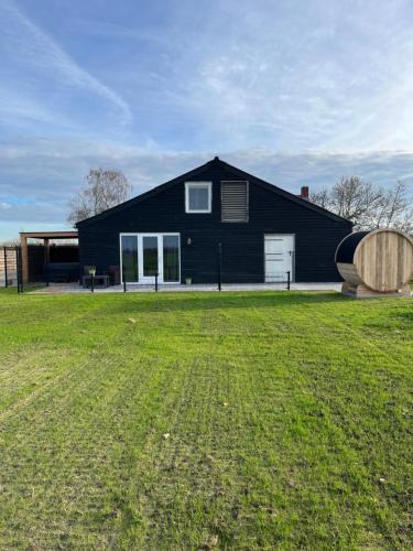 a black house with a large yard in front of it at B&B de Landstreek in Hulten