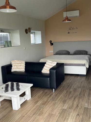 a living room with a couch and a bed at B&B de Landstreek in Hulten
