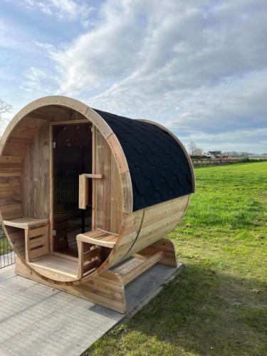 a circular wooden hobbit house in a field at B&B de Landstreek in Hulten
