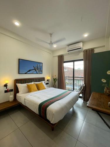 a bedroom with a large bed and a large window at Creek Harbour Fort Kochi in Fort Kochi