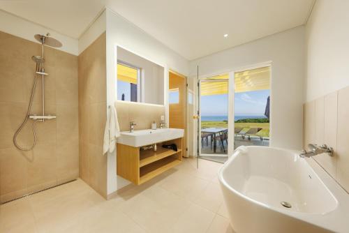 a bathroom with a tub and a sink and a shower at Center Parcs Nordborg Resort in Nordborg
