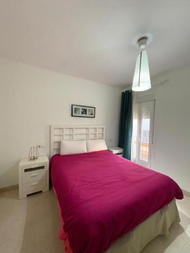 Sol De Tahona في كارمونا: غرفة نوم بسرير كبير مع بطانية ارجوانية