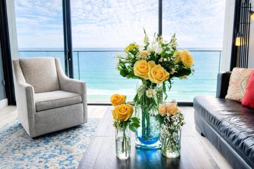a living room with a vase of flowers on a table at Ocean View Luxury Condo Oceanfront and Pool in San Diego