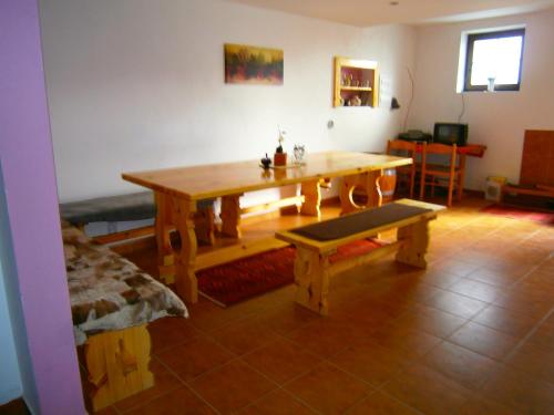 a wooden table and bench in a living room at Penzion Andrea in Velké Bílovice