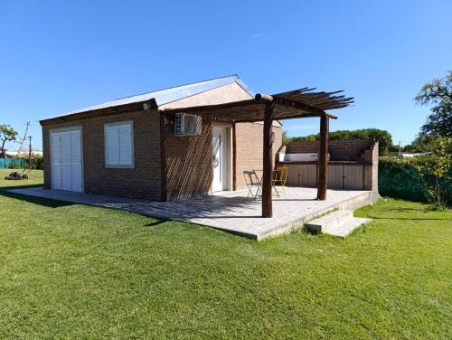 a small house with a deck in the grass at Casa Quinta en Victoria in Victoria