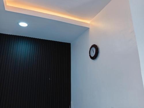 een klok op een witte muur in een kamer bij Heirloom Luxury Hotel and Apartments in Maiyegun