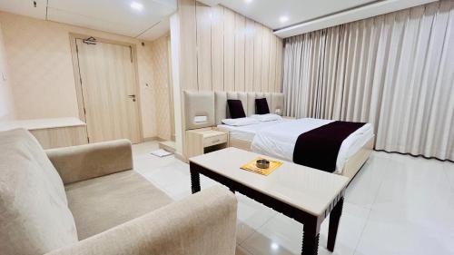 a hotel room with a bed and a couch at Avadh Hotel & Banquets in Bareilly