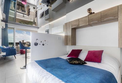 a bedroom with a large bed with red and blue pillows at Village Naturiste R4N - Le Bocca Port Nature Coursive Luxe in Cap d'Agde