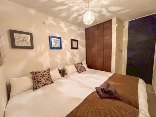 a bedroom with a large white bed with pillows at Cozy Stay Pippu in Tōma