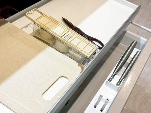 a drawer with a box with a razor and scissors at Cozy Stay Pippu in Tōma