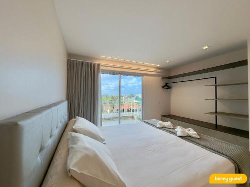 a bedroom with a large bed and a large window at Golf Ville Resort - Porto das Dunas in Aquiraz