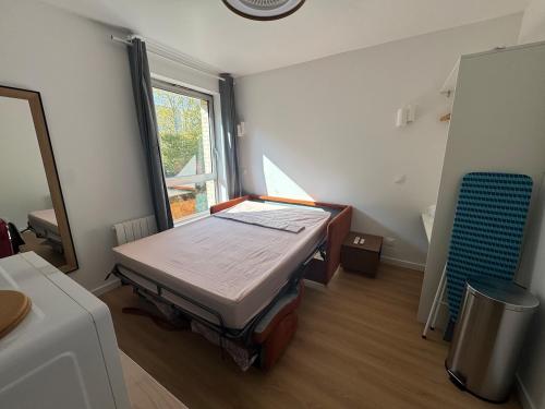 een kleine kamer met een bed en een raam bij New studio apartment hotel Palais des Congrès 11 in Levallois-Perret