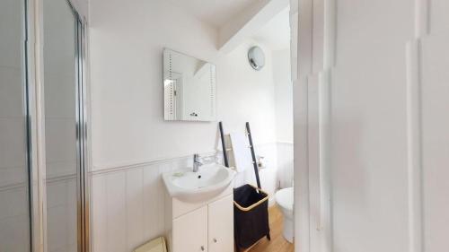 a white bathroom with a sink and a toilet at C25 Weir View, Riviere Towans in Hayle