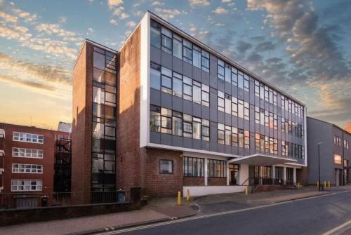 a building on a street with a cloudy sky at Fantastic 1 Bed Central Preston Apartment in Preston