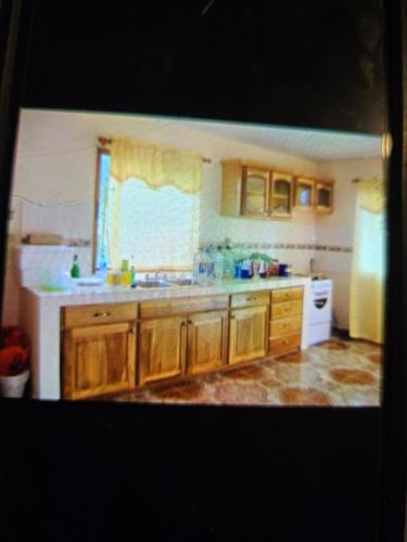 Una cocina con armarios de madera y un fregadero y una ventana. en Awesome Volcán Barú Views, en Volcán