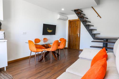 a dining room with orange chairs and a table at PureAzibo in Macedo de Cavaleiros